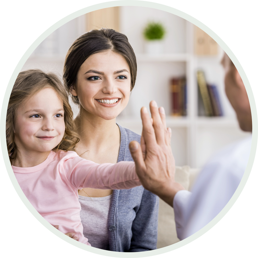 Doctor high-fiving young patient with her mother